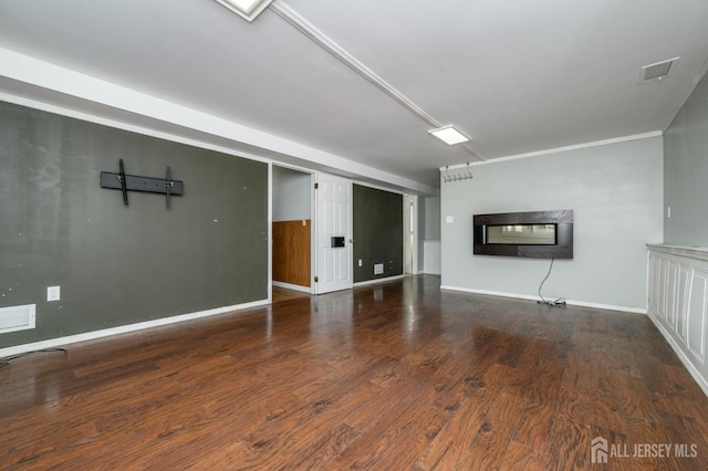 unfurnished living room featuring hardwood / wood-style floors, ornamental molding, and a multi sided fireplace