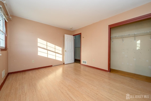 unfurnished bedroom with light hardwood / wood-style flooring and a closet