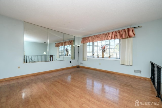 unfurnished living room with hardwood / wood-style floors and a textured ceiling