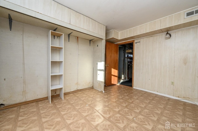 interior space with parquet flooring and wood walls