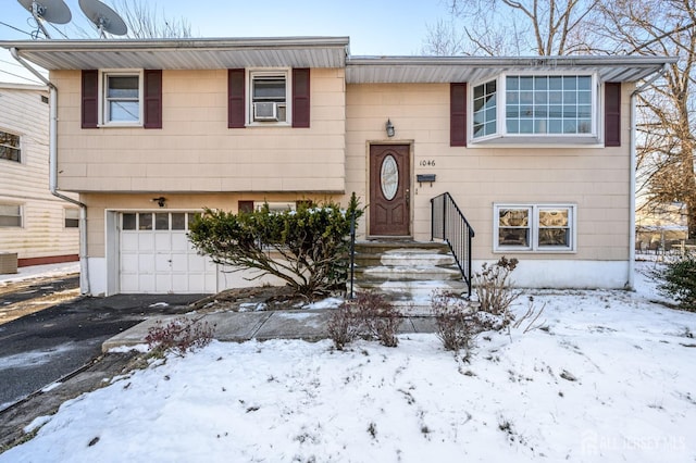 split foyer home with cooling unit, a garage, and central air condition unit