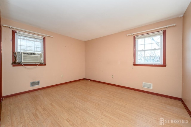 unfurnished room with cooling unit and light wood-type flooring