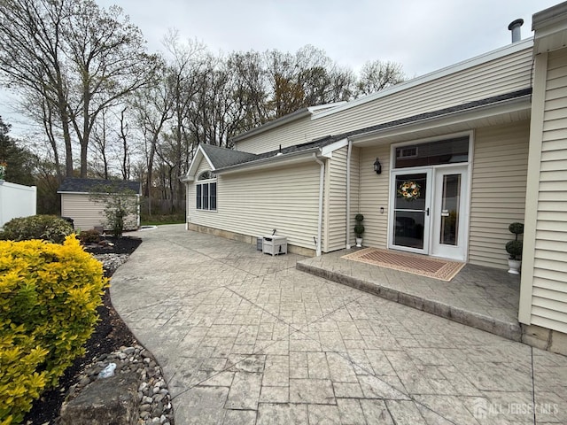 back of property with a patio, an outbuilding, and a shed