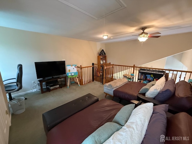 living area with attic access, carpet flooring, and ceiling fan