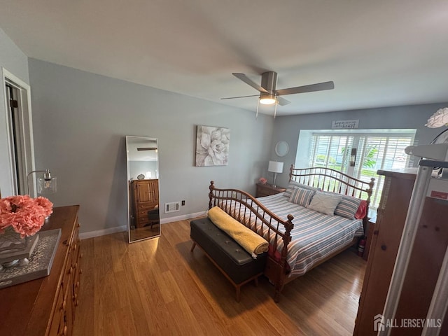 bedroom with baseboards, light wood-style flooring, visible vents, and a ceiling fan