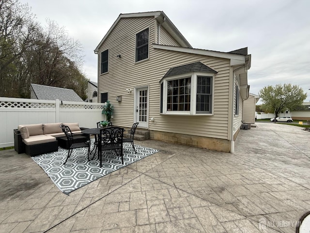 back of property featuring entry steps, a patio area, outdoor lounge area, and fence