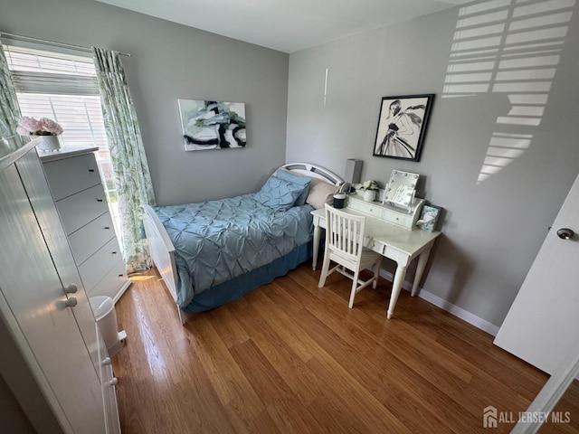 bedroom featuring wood finished floors and baseboards