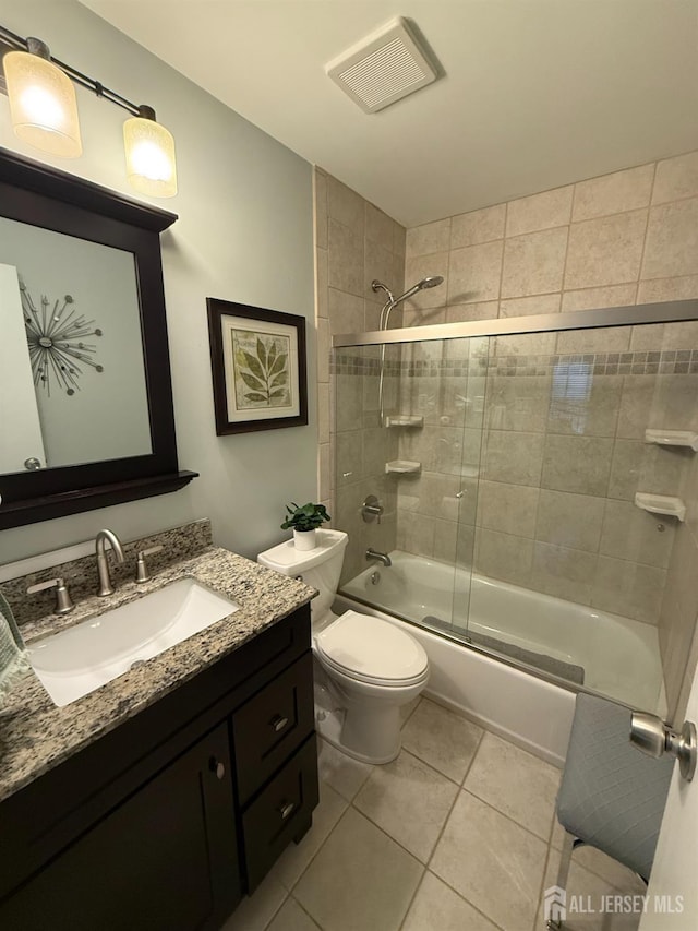 full bath featuring toilet, tile patterned floors, visible vents, bath / shower combo with glass door, and vanity