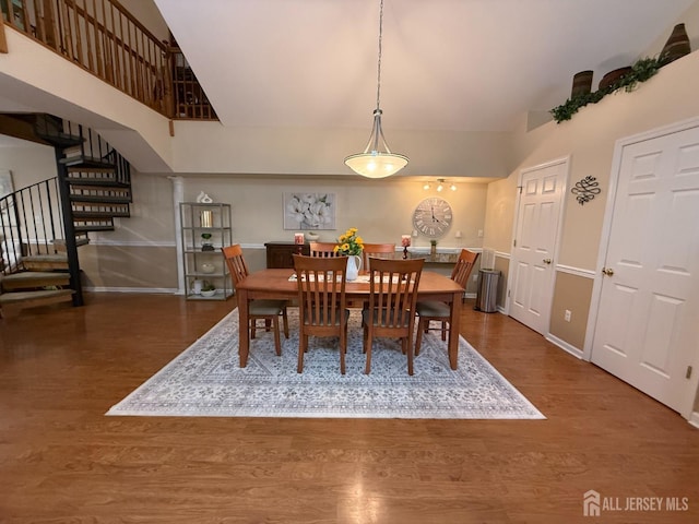 dining area featuring stairs, wood finished floors, and baseboards