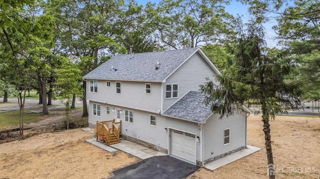 244 Lloyd Rd, Matawan, NJ 07747 - back of house featuring roof with shingles, driveway, and a garage