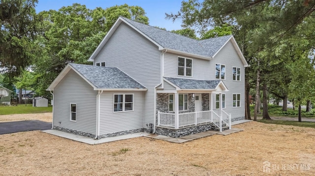 244 Lloyd Rd, Matawan, NJ 07747 - view of front of home with covered porch, a shingled roof, and stone siding