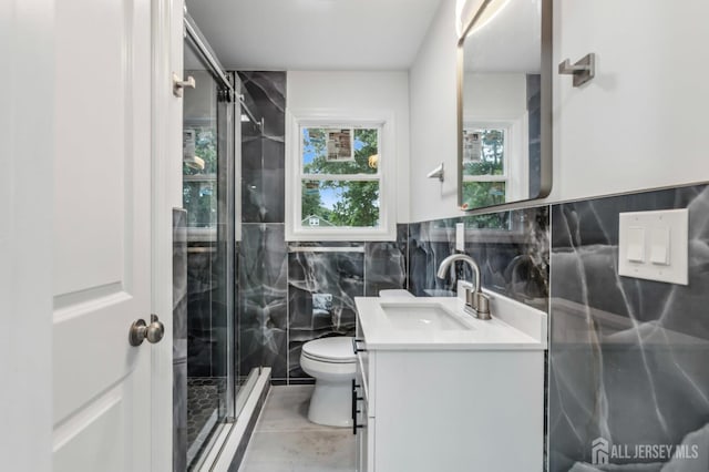 244 Lloyd Rd, Matawan, NJ 07747 - bathroom featuring vanity, toilet, tile walls, a shower stall, and a wainscoted wall