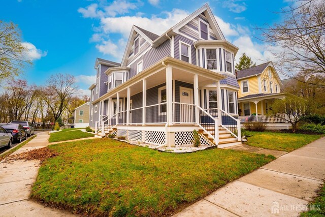 view of front of house featuring covered porch and a front lawn