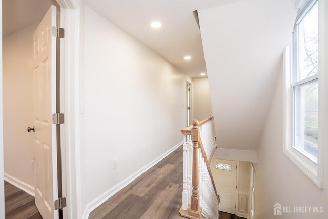 corridor with recessed lighting, an upstairs landing, baseboards, and dark wood finished floors