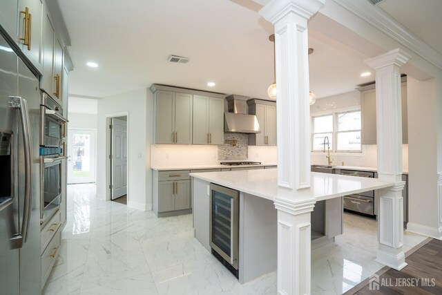 kitchen with ornate columns, range hood, beverage cooler, visible vents, and dishwasher
