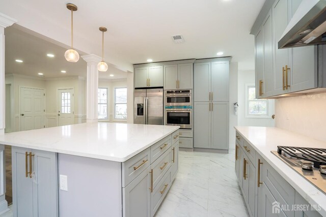 kitchen with appliances with stainless steel finishes, under cabinet range hood, marble finish floor, visible vents, and ornate columns