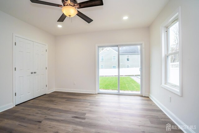 unfurnished bedroom featuring baseboards, wood finished floors, recessed lighting, and access to outside