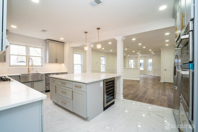 kitchen featuring marble finish floor, visible vents, wine cooler, and ornate columns