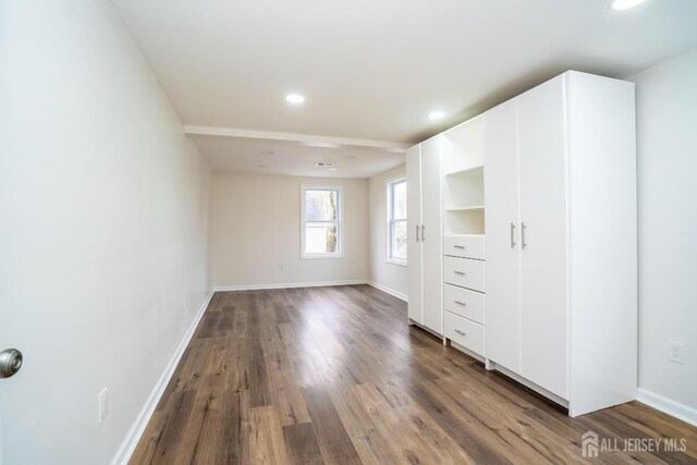 unfurnished bedroom featuring baseboards, dark wood-style floors, and recessed lighting