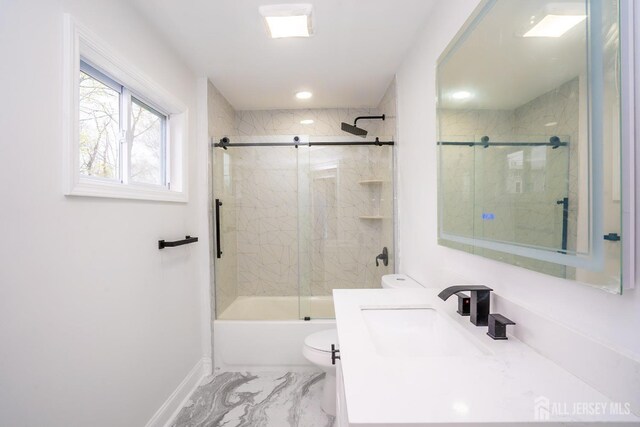 full bath featuring toilet, vanity, bath / shower combo with glass door, marble finish floor, and baseboards