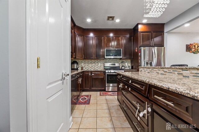 32 Cinder Rd Unit 22, Edison, NJ 08820 - kitchen with appliances with stainless steel finishes, light stone countertops, light tile patterned floors, decorative backsplash, and dark brown cabinets