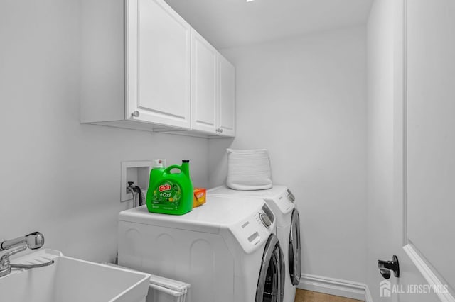 laundry area with a sink, cabinet space, and washer and clothes dryer