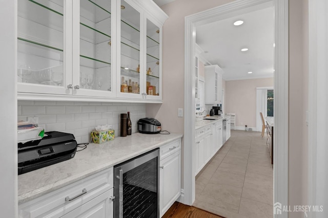 bar featuring crown molding, beverage cooler, recessed lighting, light tile patterned floors, and backsplash