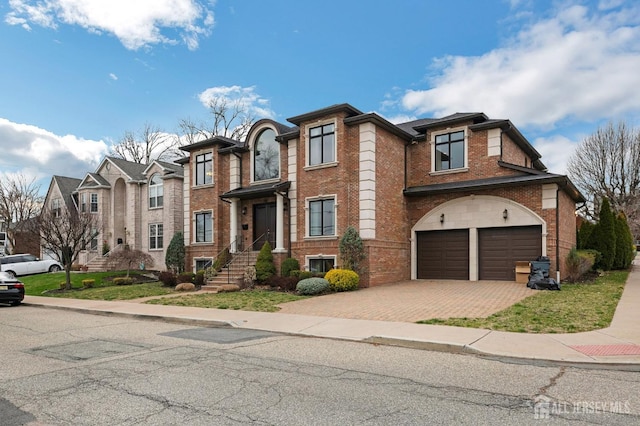 view of front facade featuring brick siding, a garage, and decorative driveway