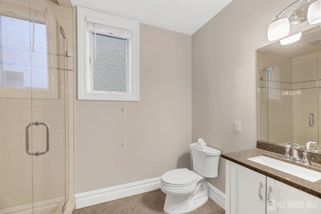 full bathroom featuring baseboards, a stall shower, toilet, and vanity