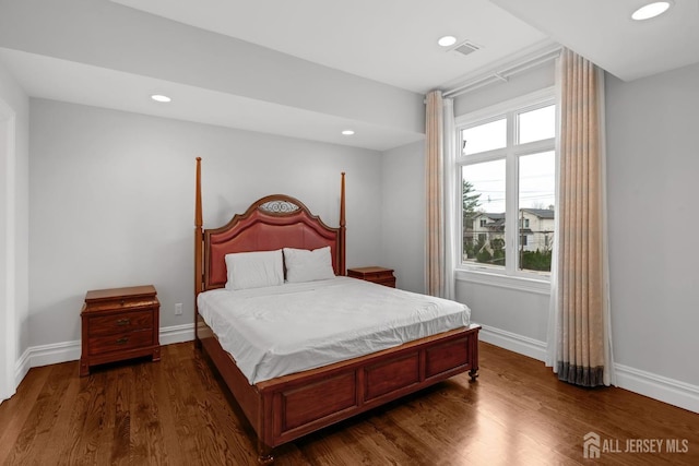bedroom featuring baseboards, multiple windows, and dark wood-style floors