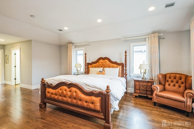 bedroom with visible vents, dark wood finished floors, and multiple windows