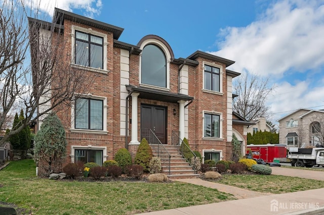 view of front of home featuring brick siding and a front lawn