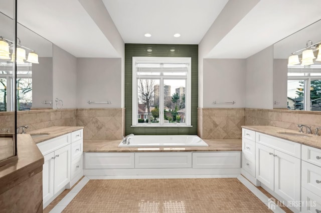 full bathroom featuring plenty of natural light, a sink, and a garden tub