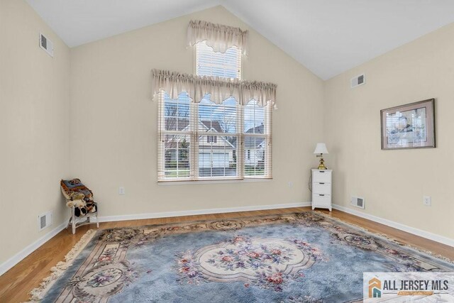interior space with a wealth of natural light, visible vents, and wood finished floors