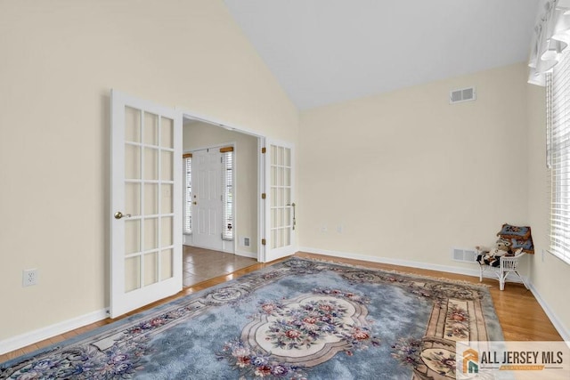 unfurnished room featuring visible vents, baseboards, french doors, and wood finished floors