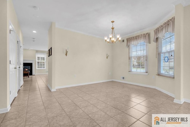 empty room with visible vents, light tile patterned floors, a notable chandelier, and plenty of natural light
