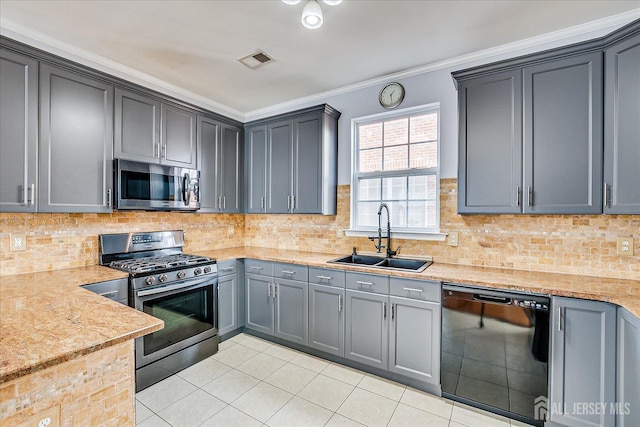 kitchen with visible vents, ornamental molding, a sink, appliances with stainless steel finishes, and decorative backsplash
