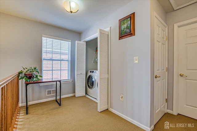 clothes washing area featuring baseboards, visible vents, laundry area, washer / clothes dryer, and light colored carpet