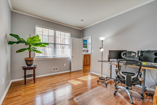 home office with visible vents, crown molding, baseboards, and hardwood / wood-style floors