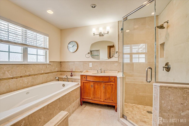 bathroom featuring a bath, a stall shower, and vanity