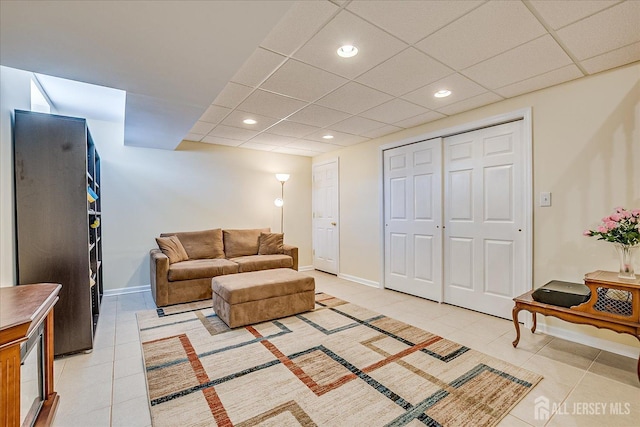 living area featuring light tile patterned floors, recessed lighting, a paneled ceiling, and baseboards