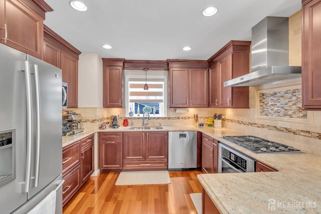 42 Ridge Rd, Edison, NJ 08817 - kitchen with stainless steel appliances, wall chimney range hood, a sink, light wood finished floors, and tasteful backsplash