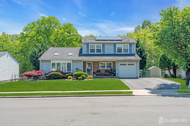 42 Ridge Rd, Edison, NJ 08817 - traditional-style house featuring roof mounted solar panels, asphalt driveway, an attached garage, a chimney, and brick siding