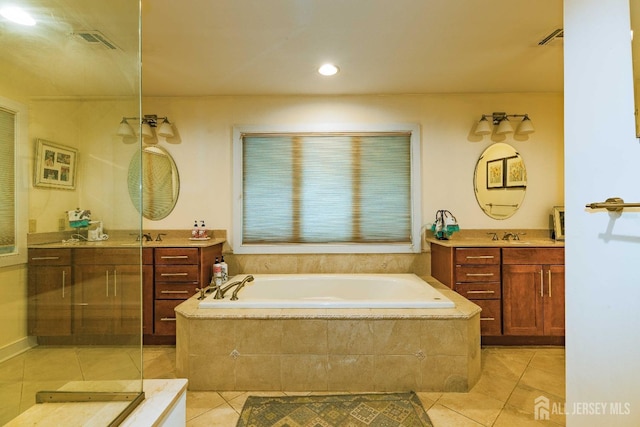 full bath featuring two vanities, visible vents, a garden tub, and tile patterned floors