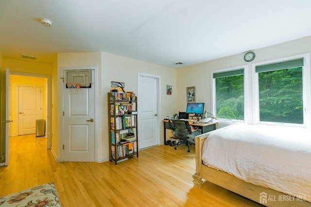 bedroom with light wood finished floors and visible vents