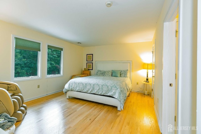 bedroom with light wood-type flooring and baseboards