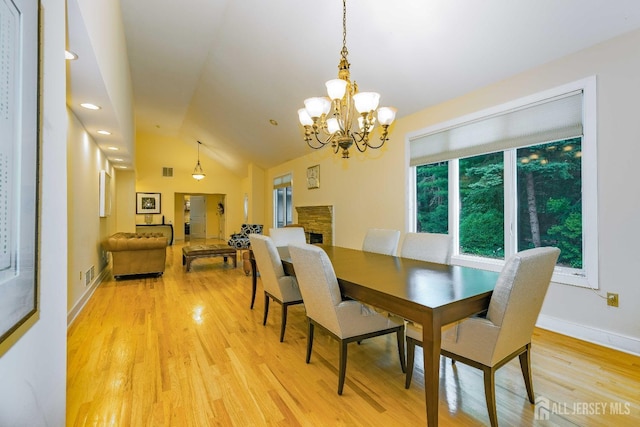 dining space with light wood-style floors, baseboards, visible vents, and vaulted ceiling