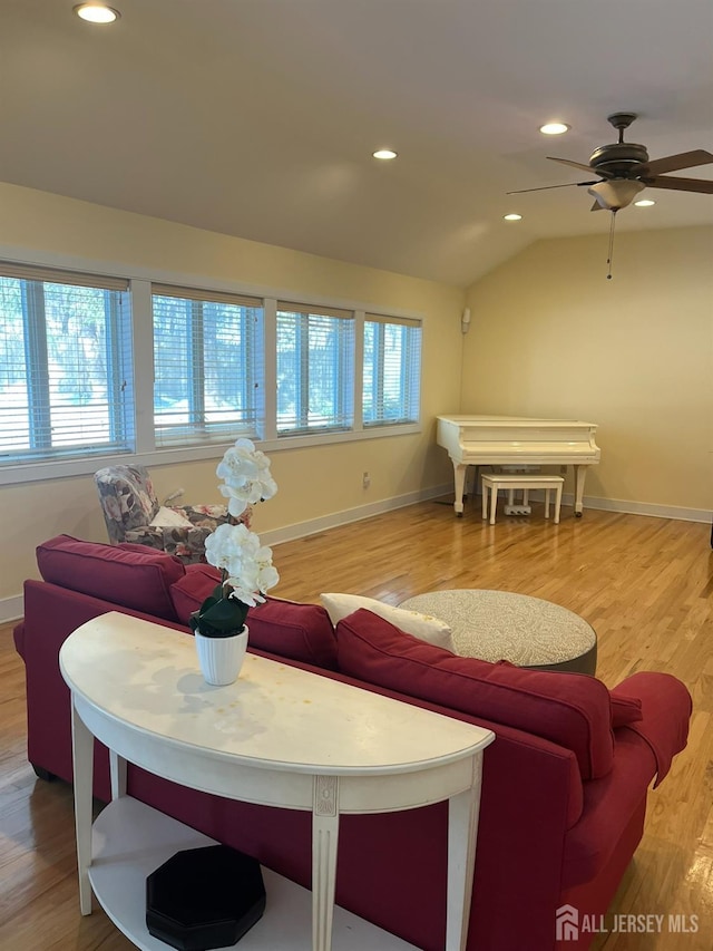 living room with vaulted ceiling, recessed lighting, wood finished floors, and a healthy amount of sunlight