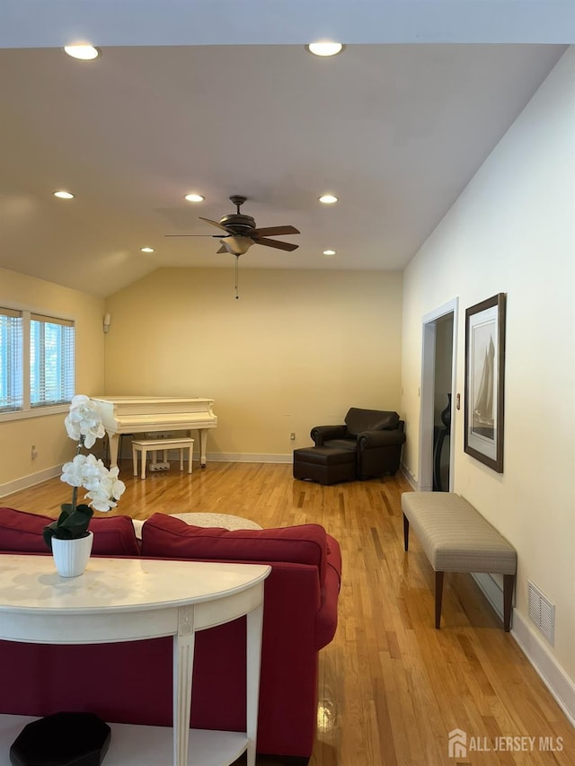 living area featuring baseboards, visible vents, wood finished floors, vaulted ceiling, and recessed lighting