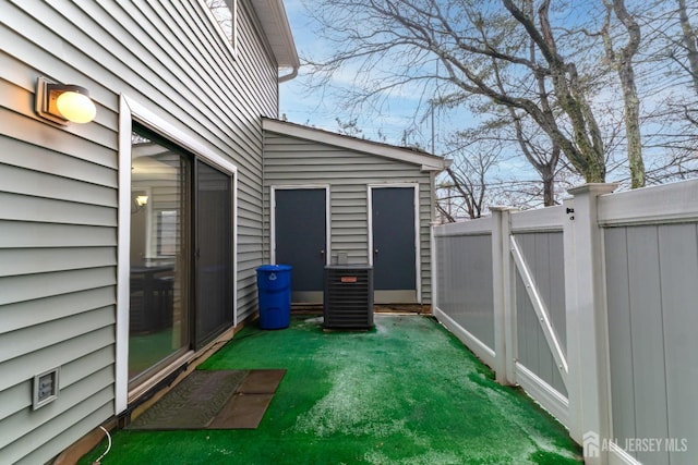 exterior space featuring a gate, fence, and central AC